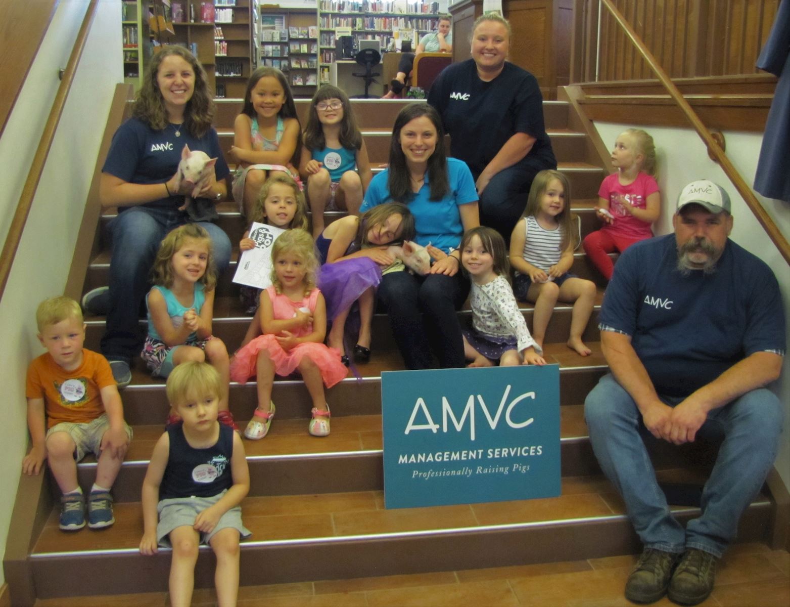 AMVC employees pose with some of the children that attended the Piglet Storytime at the Colfax-Perry